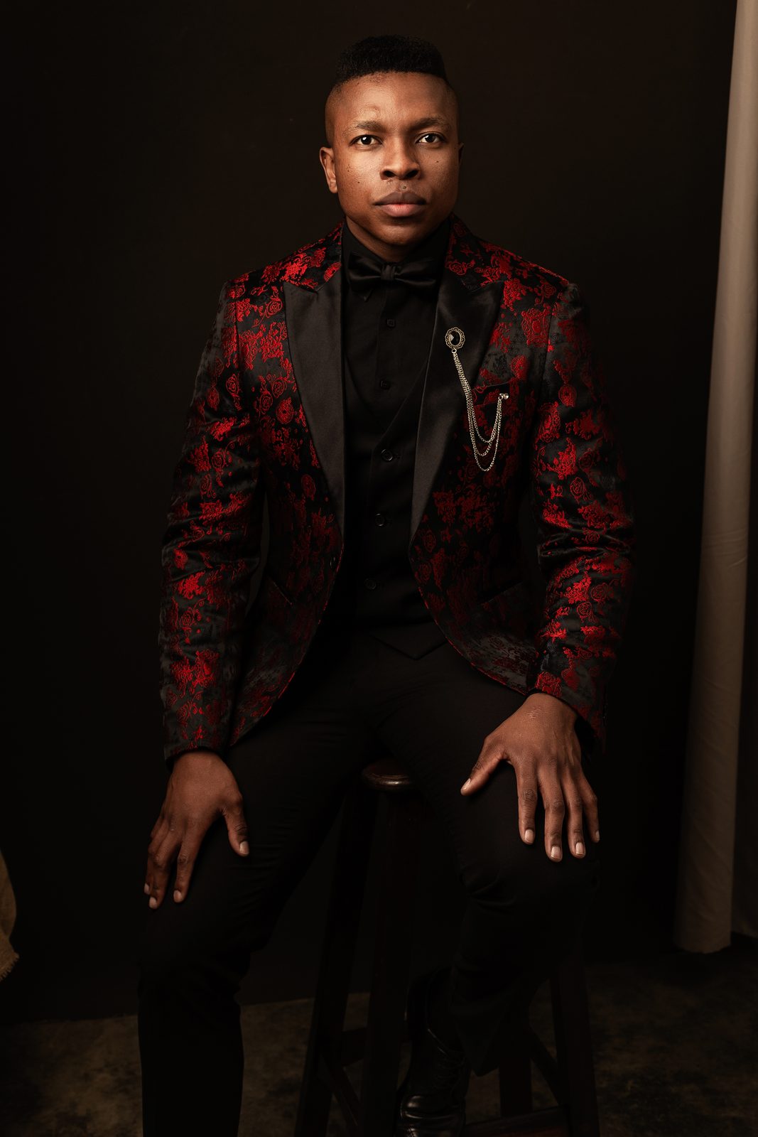 Studio portrait of Thuba Myeki in a red brocade jacket