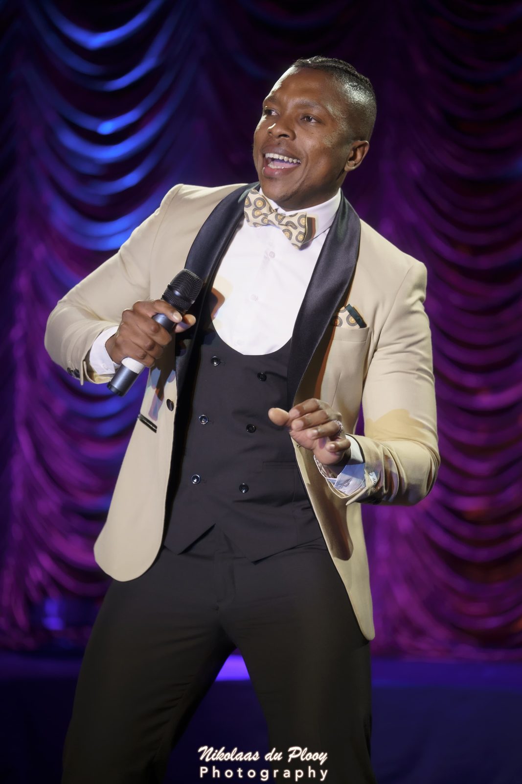 Thuba Myeki working the crowd in a cream tuxedo